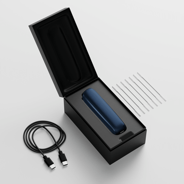 Caja de Ploom AURA abierta mostrando el dispositivo, su cable de carga y los bastoncillos de limpieza.