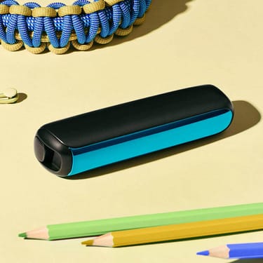 Primer plano de un accesorio Panel Frontal Ocean Blue para Ploom AURA sobre un escritorio