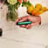 Mano sosteniendo un dispositivo Ploom con el panel frontal Amazon Green