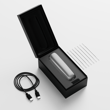 Caja de Ploom AURA abierta mostrando el dispositivo, su cable de carga y los bastoncillos de limpieza.