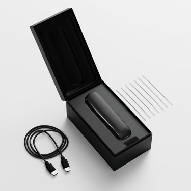 Caja de Ploom AURA abierta mostrando el dispositivo, su cable de carga y los bastoncillos de limpieza.
