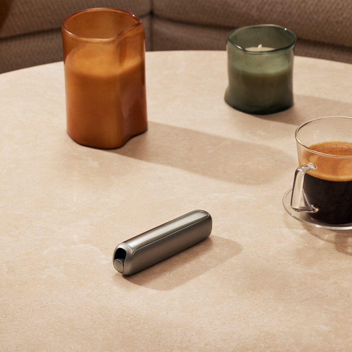 Accesorio Panel Frontal Lunar Silver para Ploom AURA sobre una mesa.